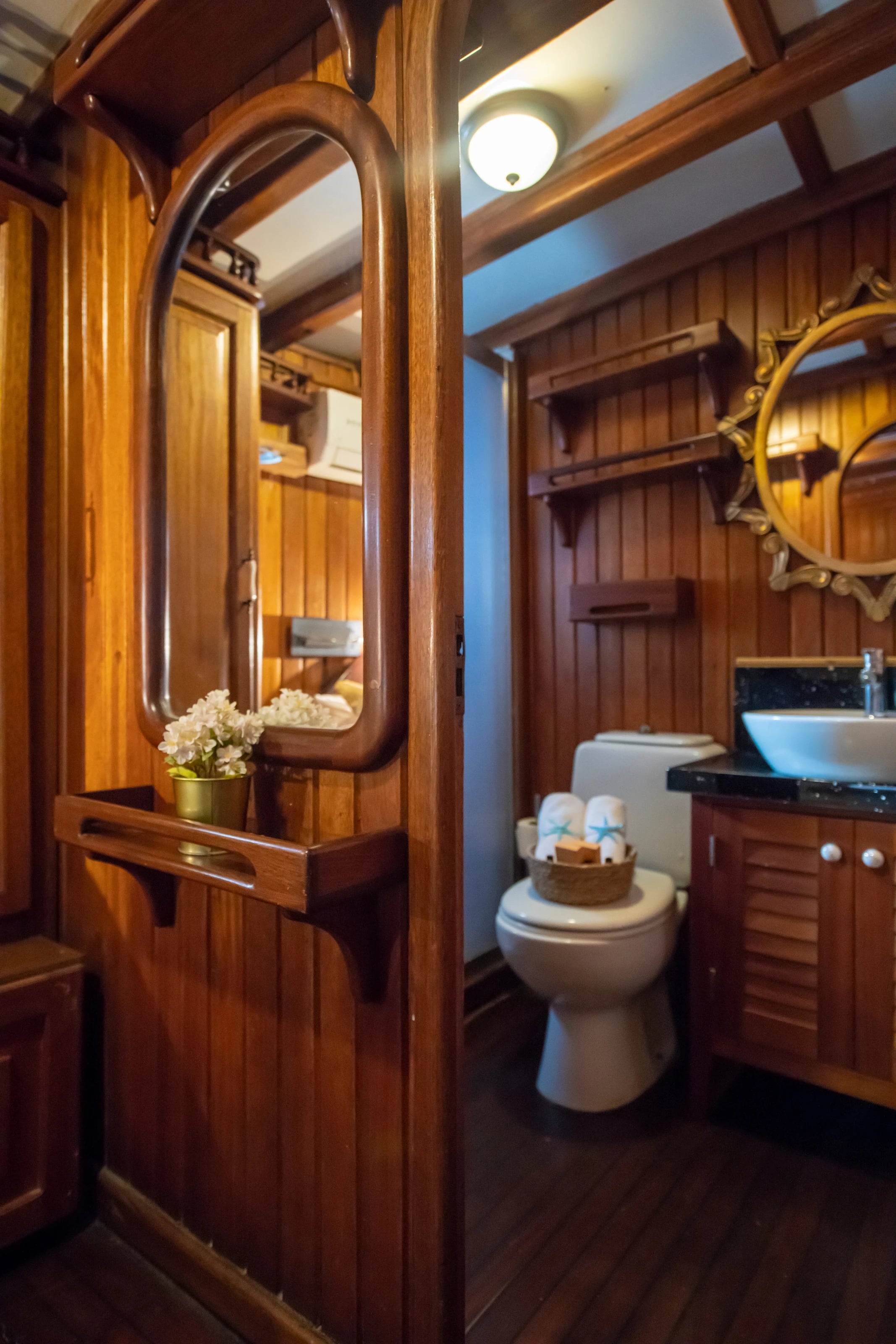 Das eigene Bad einer Kabine auf der Northwind mit Holzverkleidung, Waschbecken und WC.