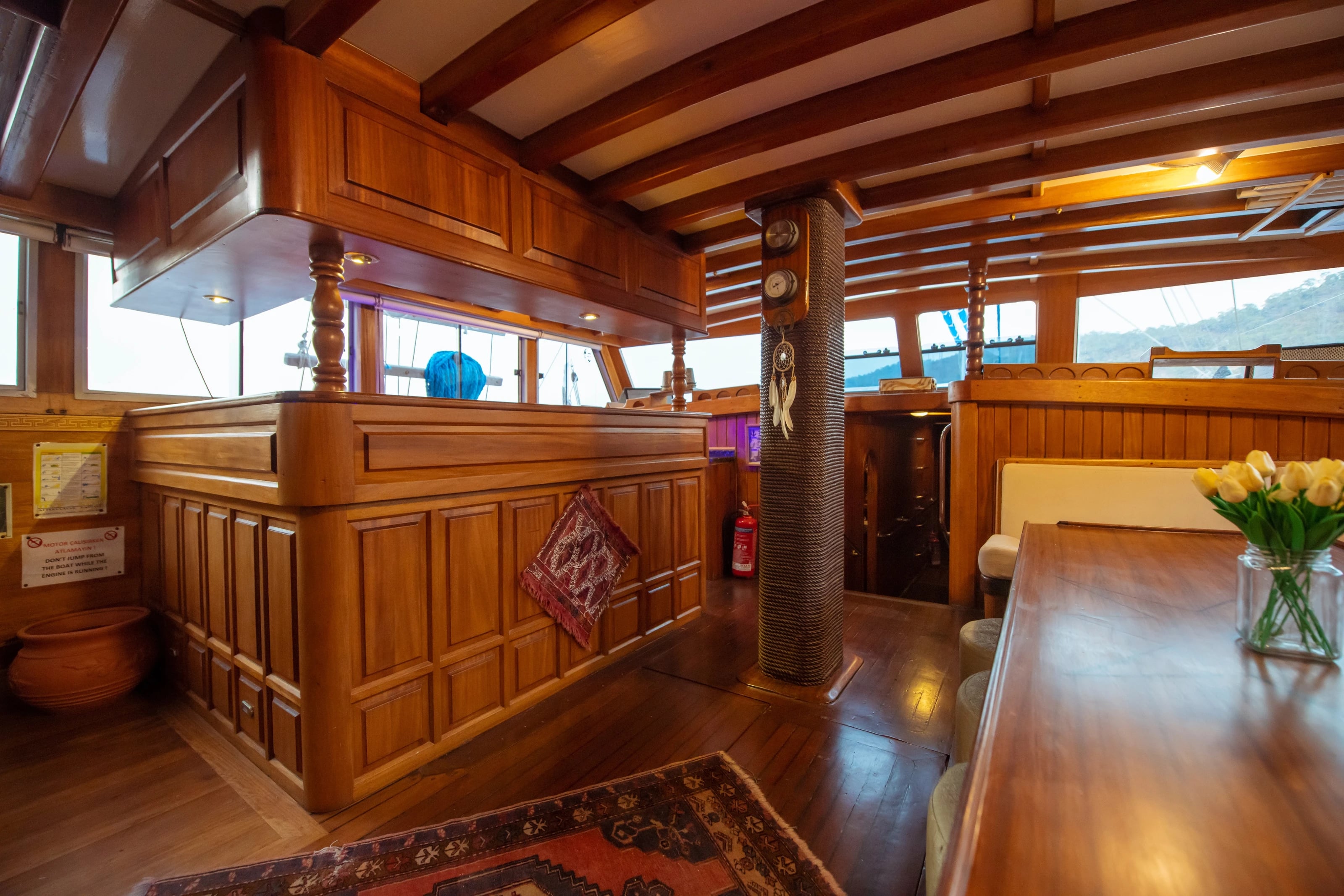 Der Salon der Northwind mit Holzvertäfelung, Bar und Teppich, durch die Fenster sieht man die Bucht.