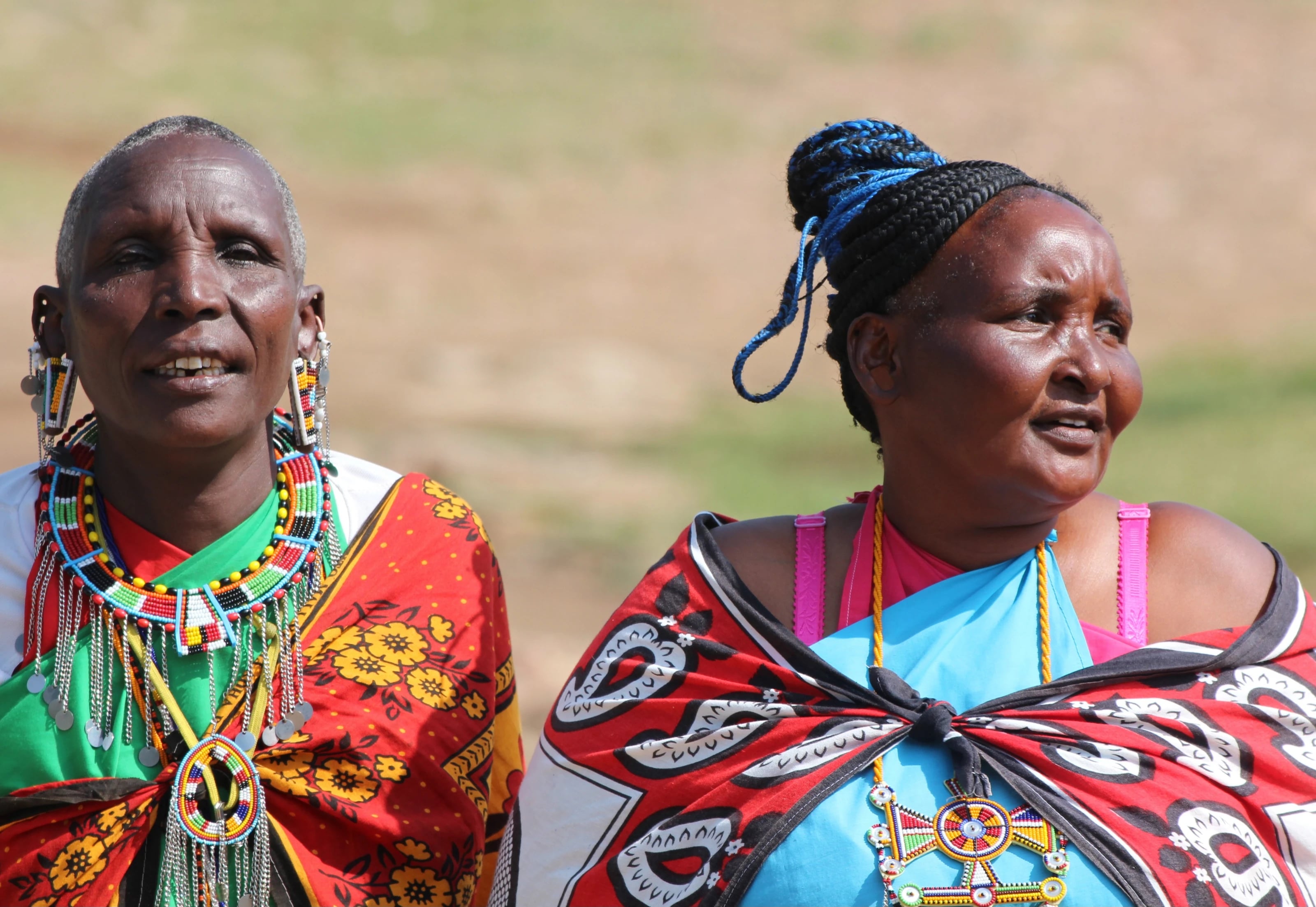 Zwei Maasai-Frauen in farbenfrohen Tüchern und mit Perlenschmuck.