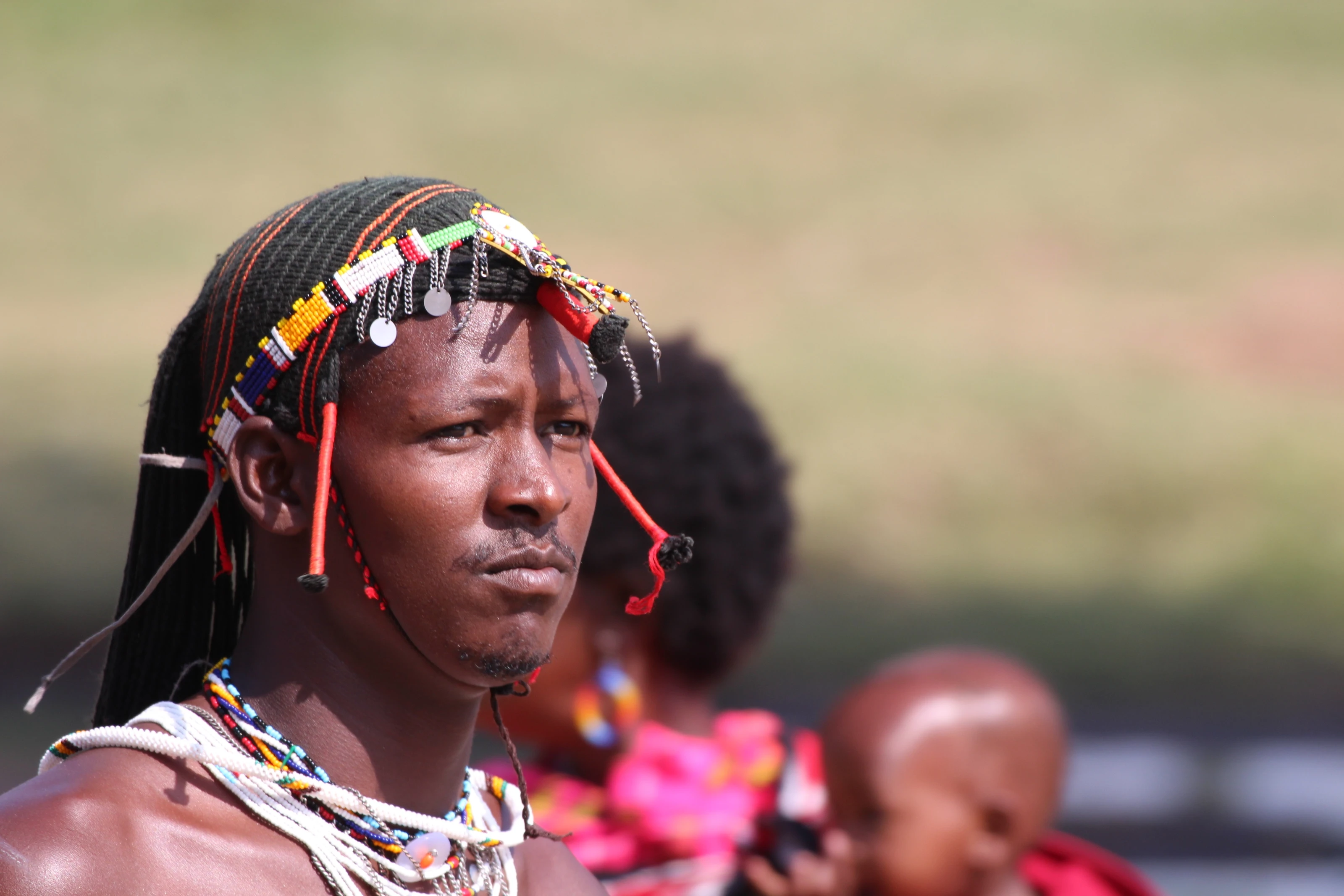 Junger Maasai mit geflochtenem Haar und buntem Perlenschmuck.