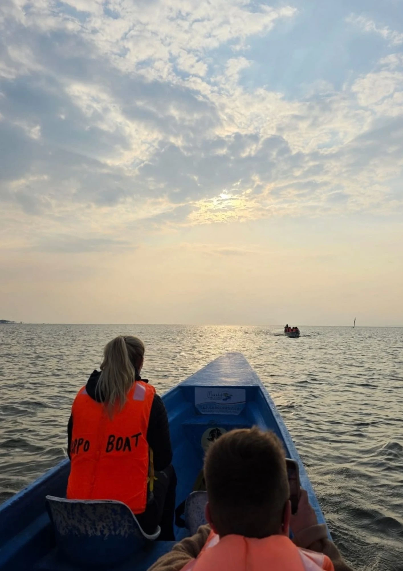Teilnehmerinnen in Schwimmwesten fahren im Abendlicht mit dem Boot über den Lake Naivasha.
