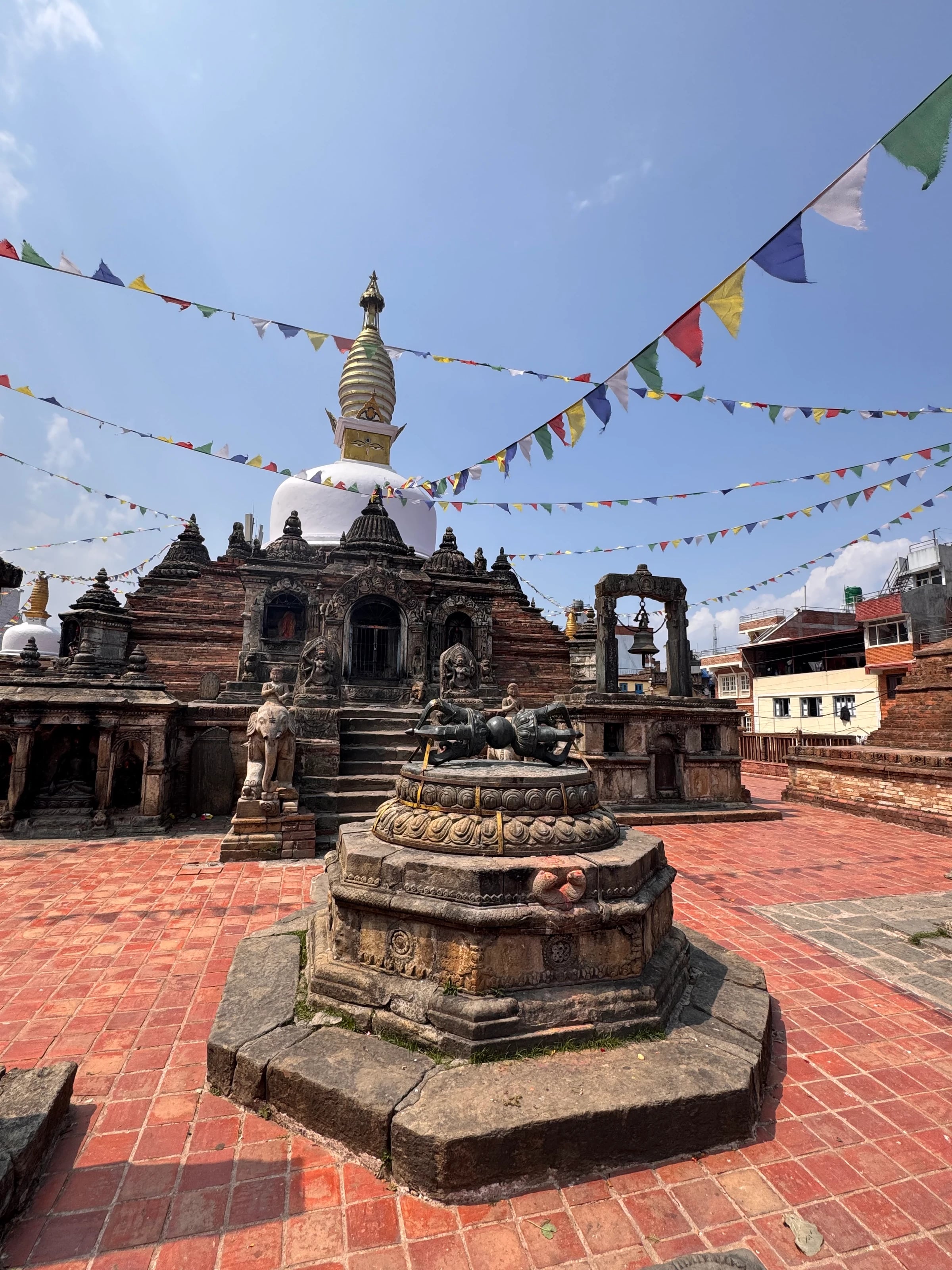 Ein steinerner Tempel am Durbar Square in Bhaktapur, geschmückt mit bunten Gebetsfahnen.