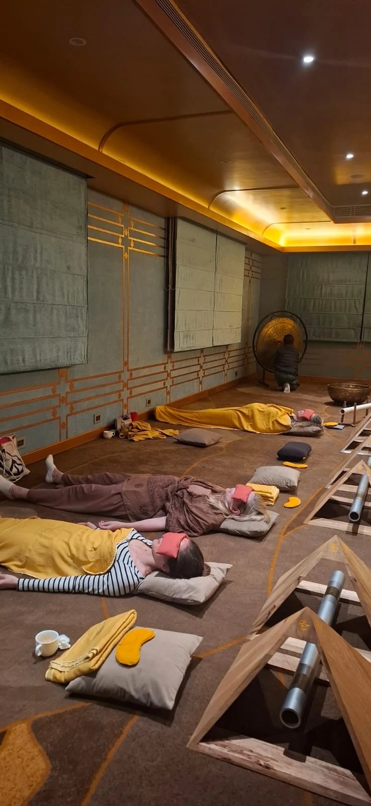 Retreat-Teilnehmerinnen liegen entspannt am Boden während einer Klangbad-Session mit Gong.