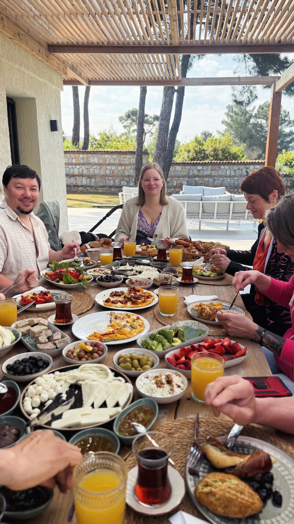 Reich gedecktes Frühstück unter der Pergola mit der Gruppe