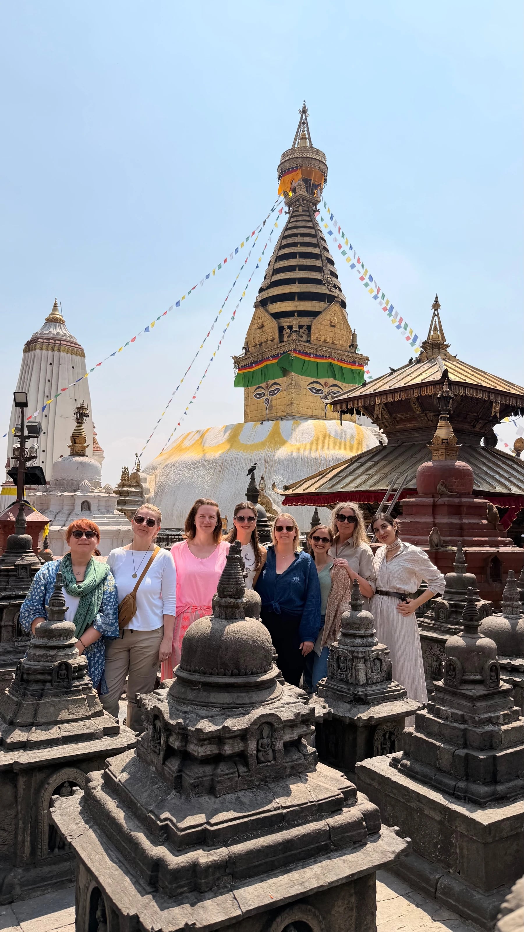 Reisegruppe zwischen kleinen Votiv-Stupas mit Blick auf die große Stupa von Swayambhunath.
