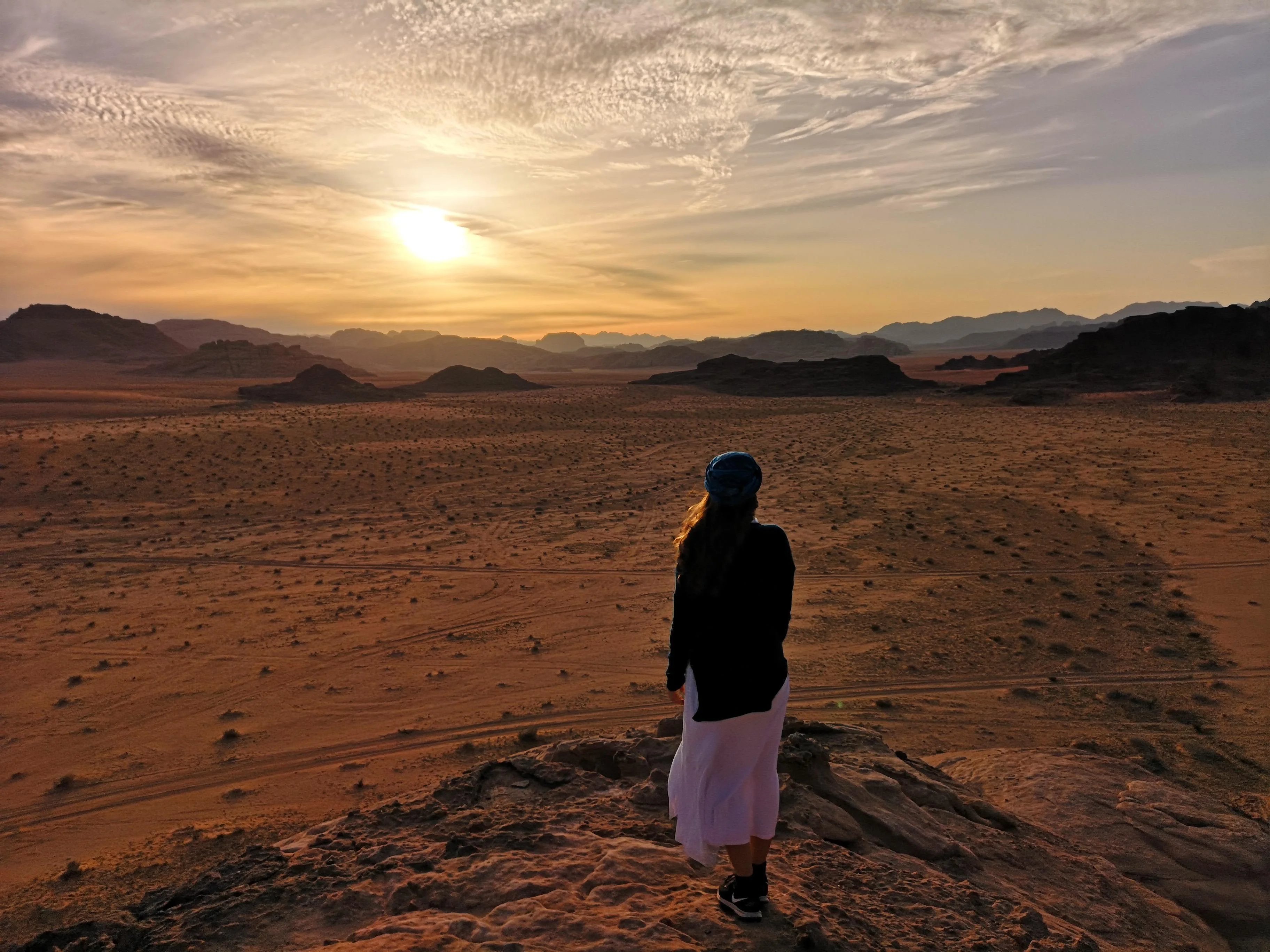 Selin blickt bei Sonnenuntergang über die weite Wüstenlandschaft von Wadi Rum